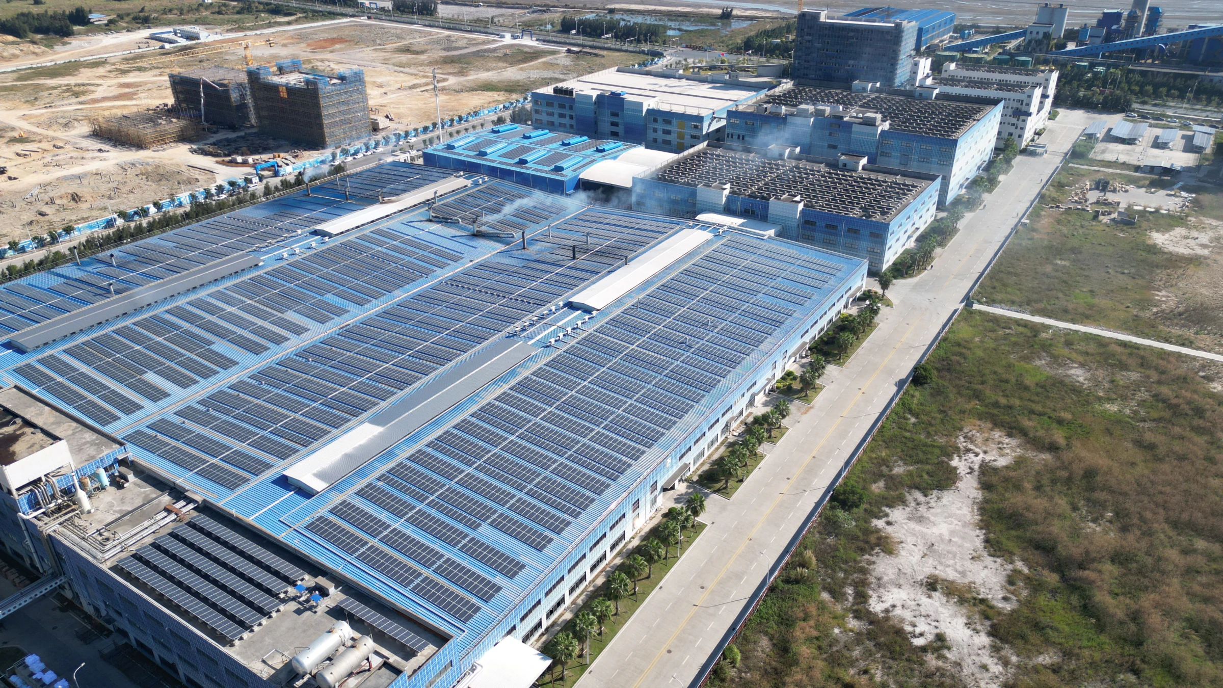 Stort industrianlegg med solcellepaneler over mesteparten av takflaten